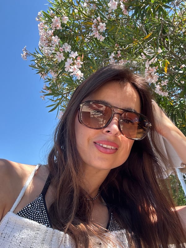 Woman enjoys sunny morning at coastal location, takes selfies