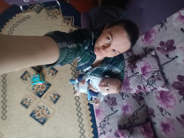 Parent and baby photographed together in Ольховка home