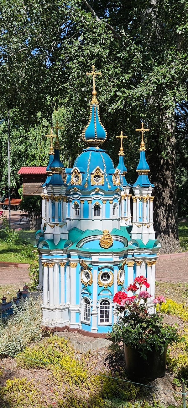 Miniature blue and white architectural models on display in a park