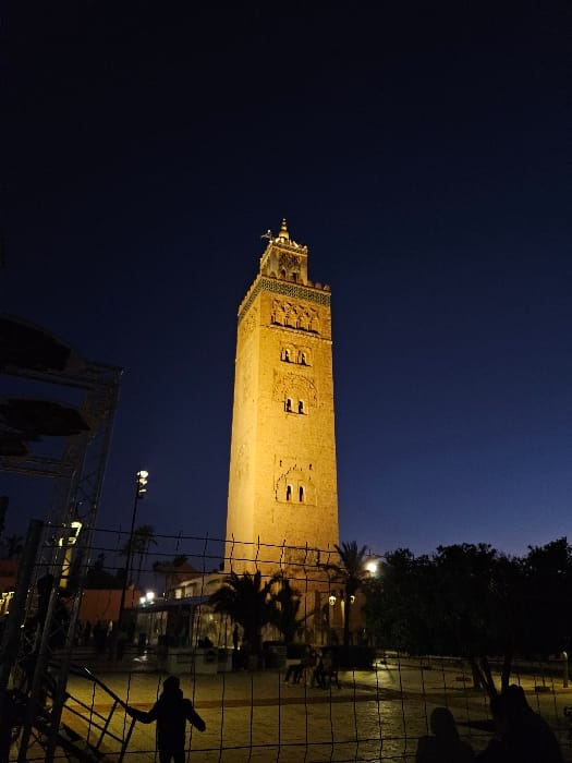 Evening stroll captures illuminated Koutoubia Mosque in Marrakesh twilight