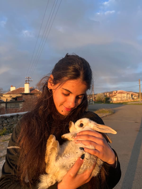 Woman plays with rabbit in Bulgarian garden