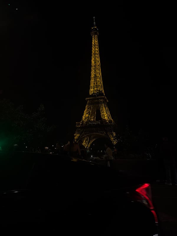 Eiffel Tower glows golden against night sky in Paris