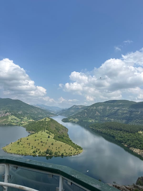 Tourist documents scenic reservoir views across Bulgarian mountains