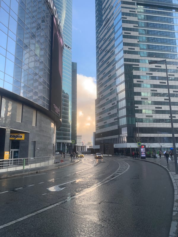 Man takes selfie on wet Khimki street amid skyscrapers