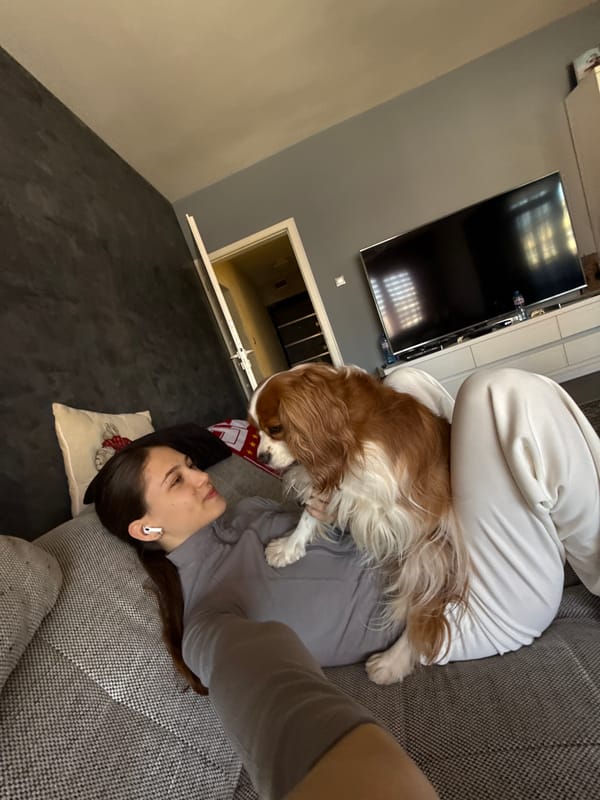 Woman relaxes with dog on sofa in Sofia home