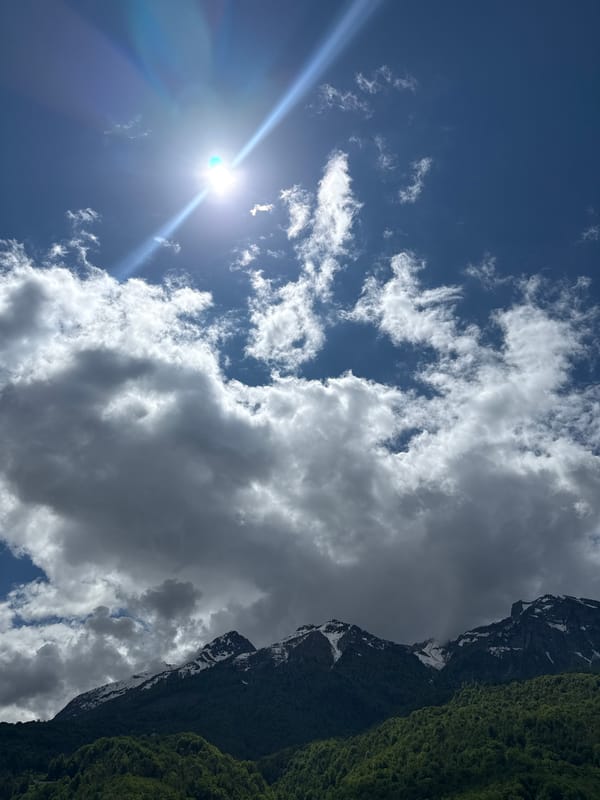 Morning sunlight breaks through clouds over Krasnaya Polyana mountains