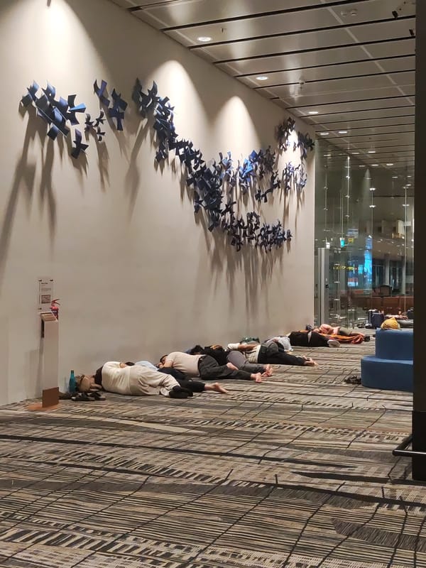 Travelers sleep on airport terminal floor in Singapore