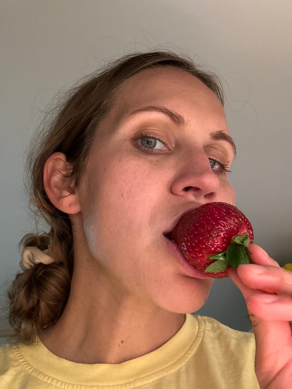 Woman enjoys large strawberry in Fethiye, Turkey