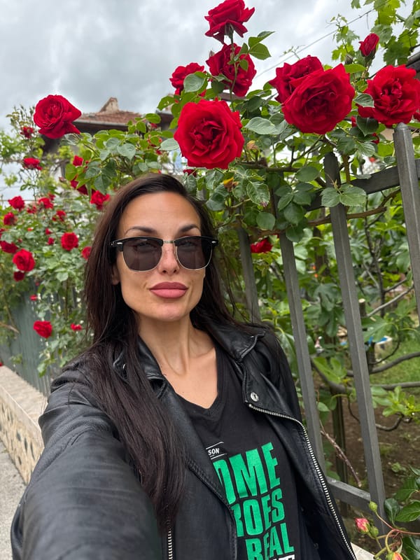 Woman poses with blooming roses in Lovech, Bulgaria