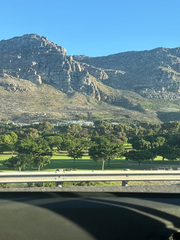 Passenger uses phone while traveling past Table Mountain, Cape Town