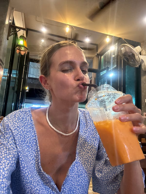 Woman enjoys orange drink in Patong cafe