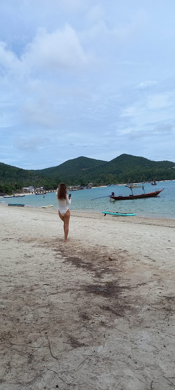 Woman with paddleboard spotted at Thai beach among boats