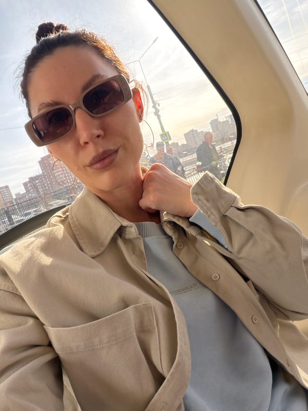 Woman takes selfie in vehicle with Perm cityscape backdrop