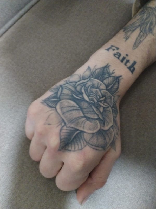 Tattooed hand and forearm displayed in Ghent