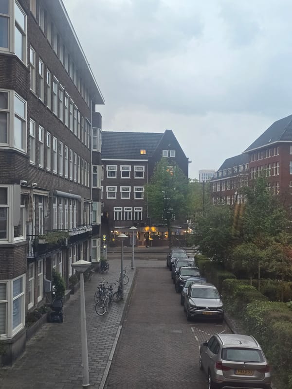 Urban street scene with brick buildings, cars documented