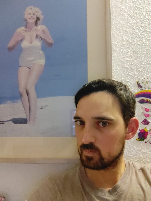 Man photographed with Marilyn Monroe beach poster behind him