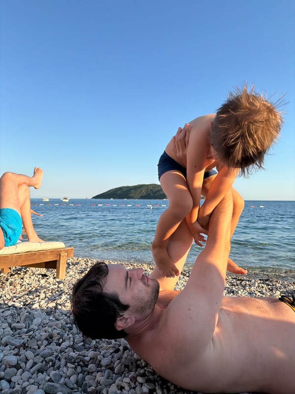 Beachside balancing act with a toddler on a Budva pebble beach