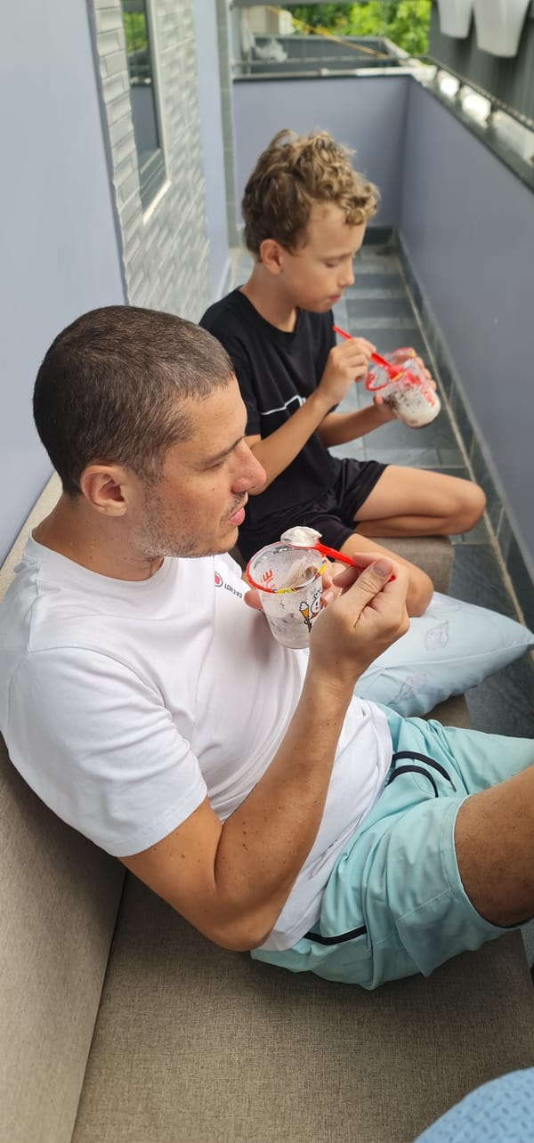 Father and child share boba tea on Đà Nẵng patio