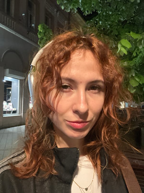 Woman takes evening selfies near Frida Kahlo banner in Novi Sad