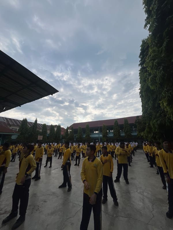 School students in yellow uniforms drill and gather in Lhokseumawe