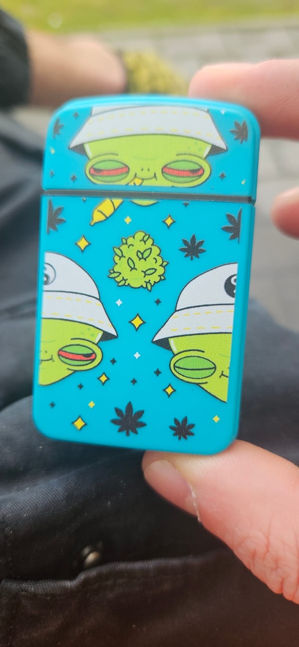 Person holds cannabis-themed container with cartoon frogs in Plovdiv