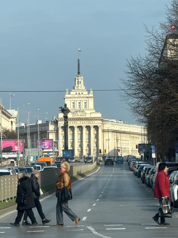 Sofia street traffic and pedestrians near classical government building