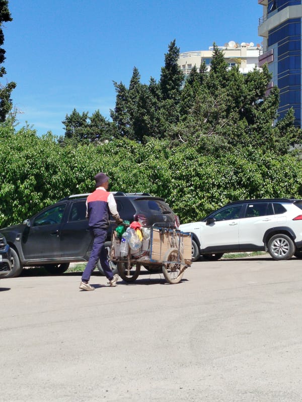 Man pulls cart of recyclables through Meknes streets