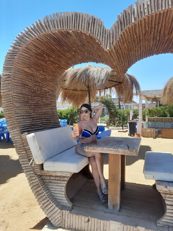 Woman relaxes in wooden shelter structure in Hurghada