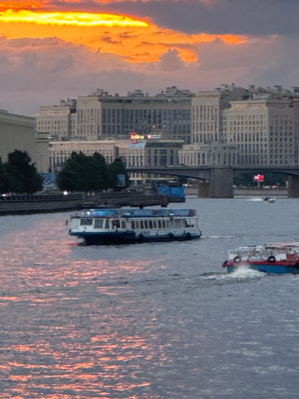 Sunset boat traffic and city streets along Saint Petersburg's Neva River