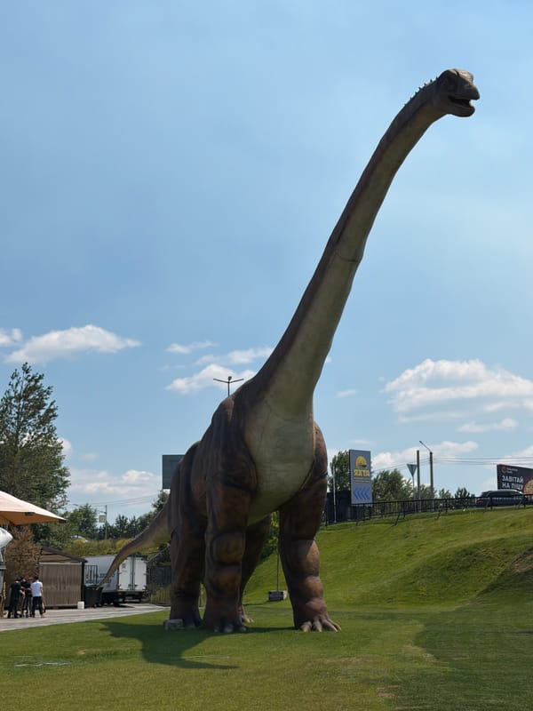 Outdoor celebration in Khotianivka park with dinosaur statues nearby