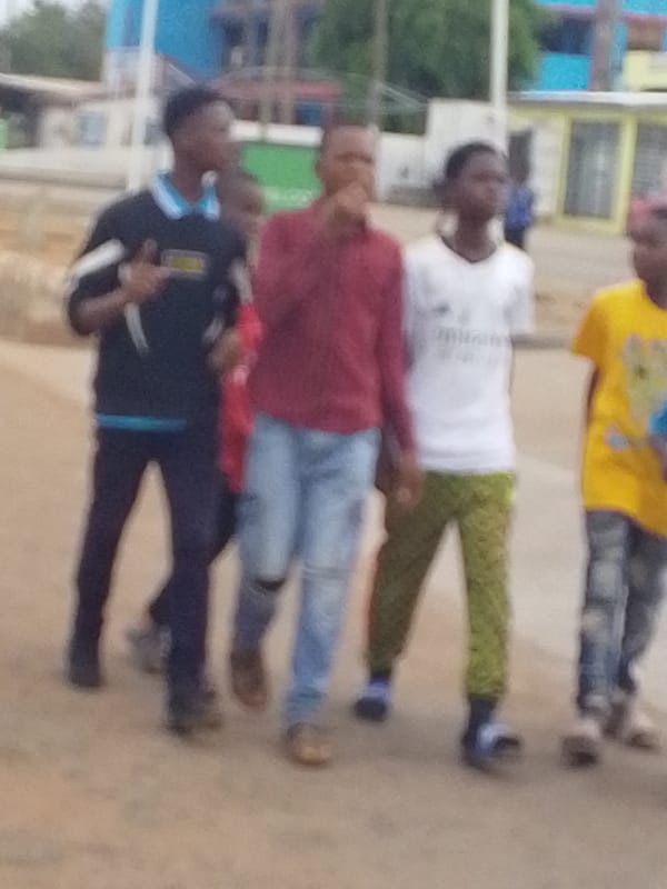 Group of young people walk through Tamale residential area