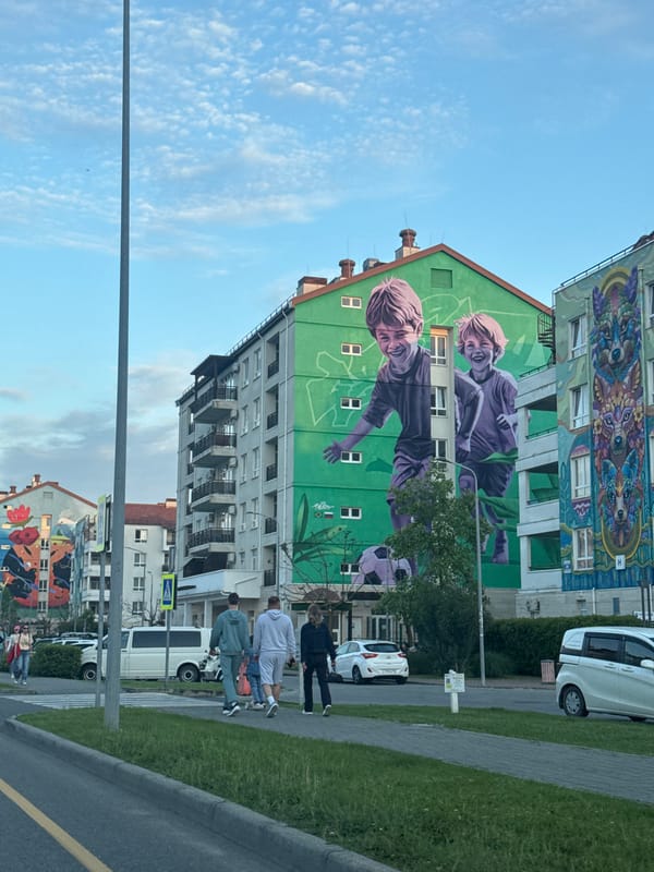 Pedestrians gather near mural-decorated building in Sirius, Russia