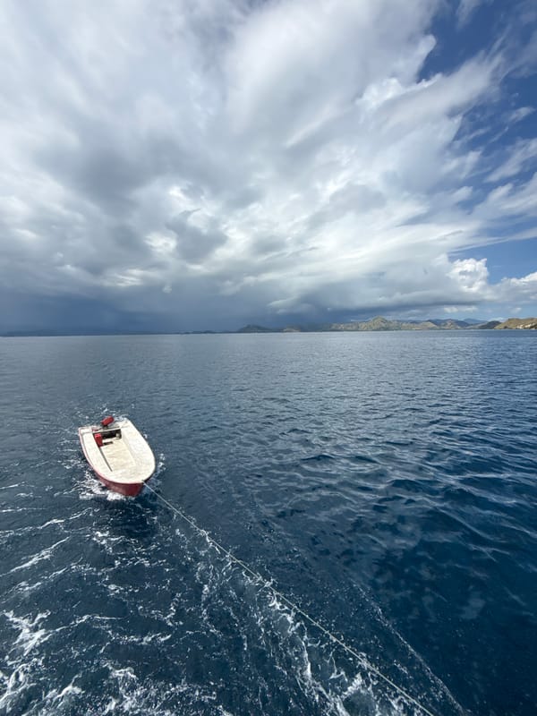 Small boat towed across waters near Pasir Putih, Indonesia