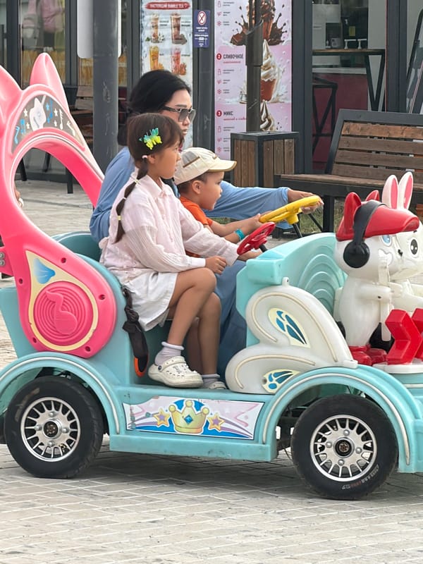 A busy outdoor amusement park on a late afternoon visit