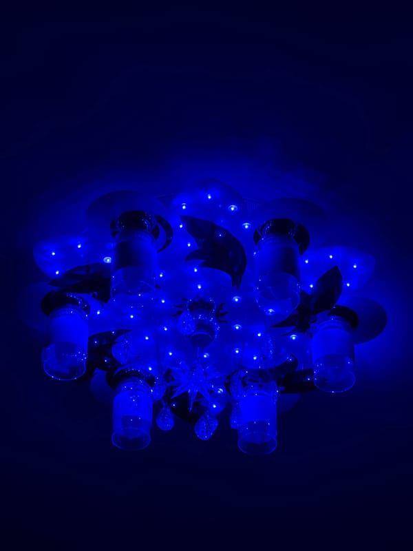 Decorative chandelier with glass cylinders observed emitting colored light