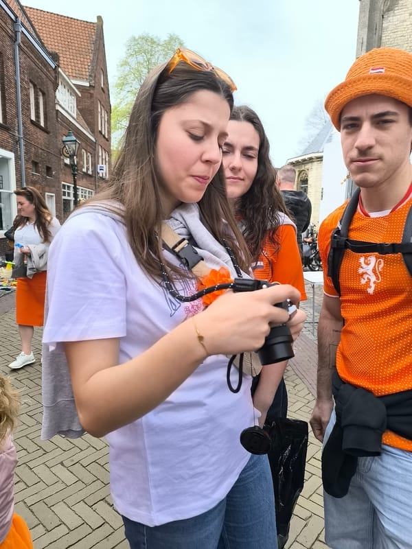 Woman examines camera on street in Alkmaar
