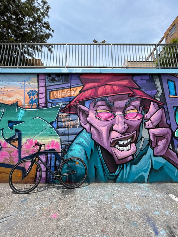 Man poses with basketball against colorful Barcelona street art