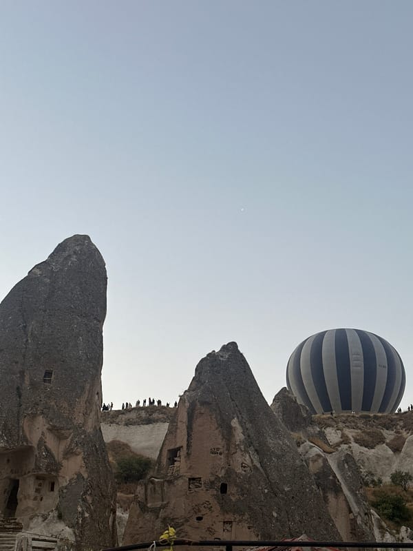 Hot air balloons rise over Göreme's rock formations at dawn