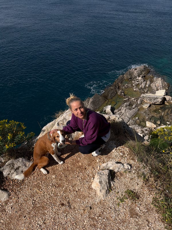 Woman and dog enjoy morning cliff walk in Montenegro
