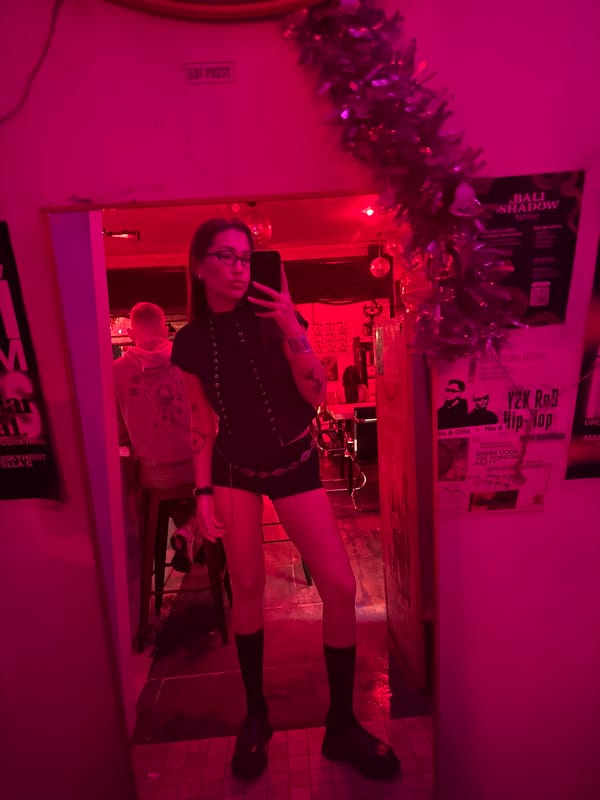Women take mirror selfies in colorful North Kuta bar
