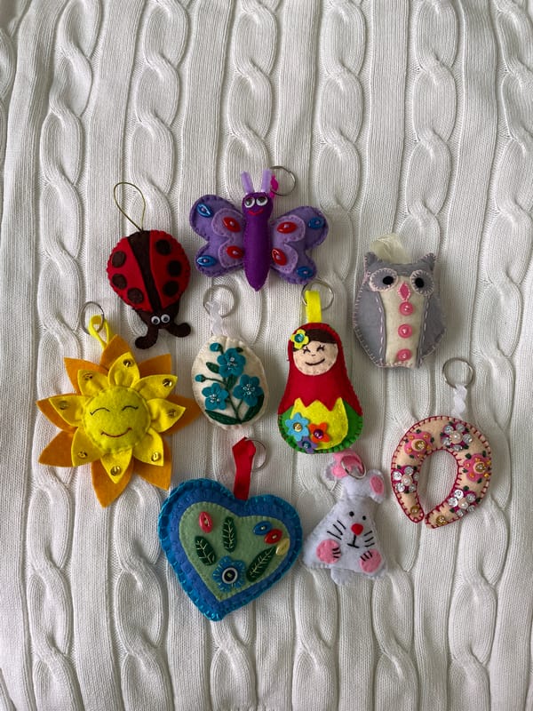 Handmade felt keychains displayed on knitted fabric in Sharapovo