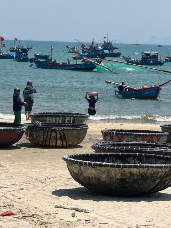 Traditional fishing boats and drying catch on Đà Nẵng beach