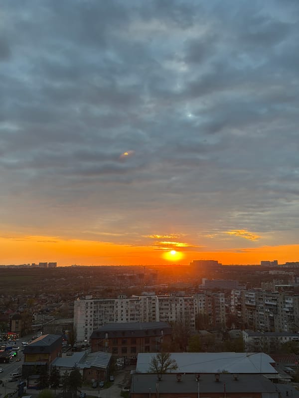 Sunset illuminates urban construction site with cranes and buildings