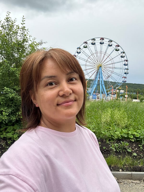 Colorful Ferris wheel and fairground area on a cloudy day