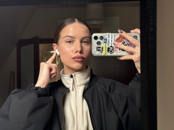 Woman takes mirror selfie while adjusting earbuds in Gdańsk