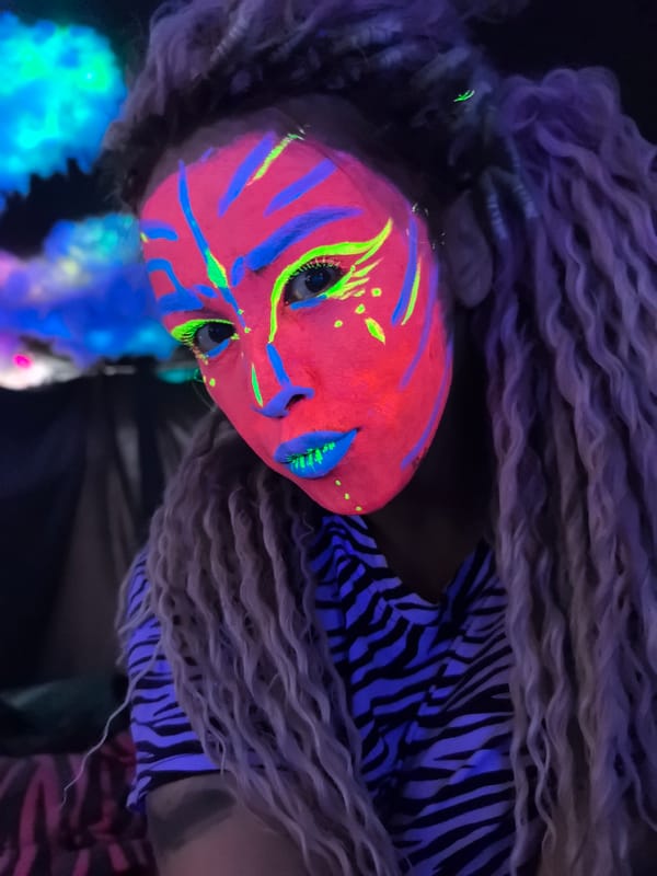 Artist documents neon makeup session with props in Noviy