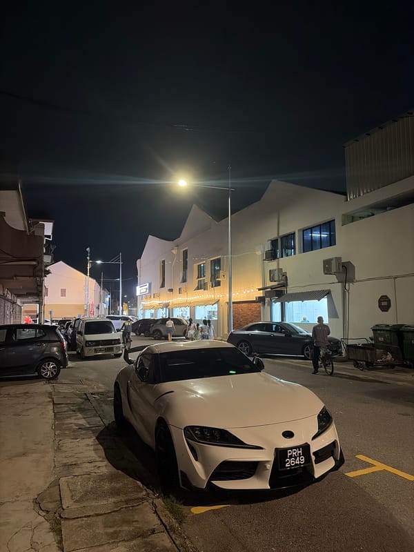 White Toyota Supra parked on a city street at night