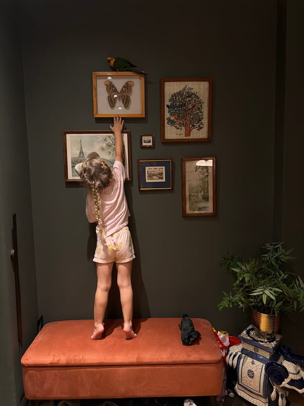 Reaching up to touch wall art in a Khimki apartment