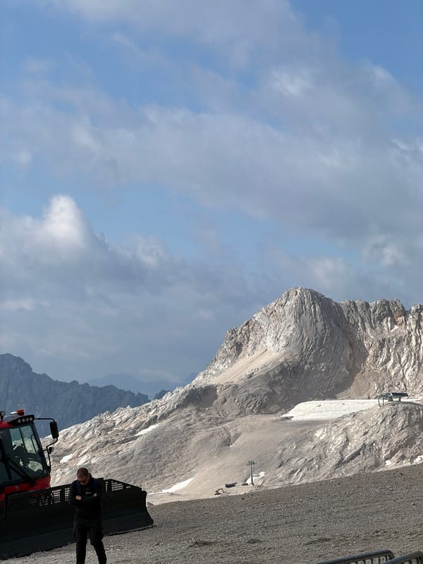 Red snow groomers parked on summer terrain in the Bavarian Alps
