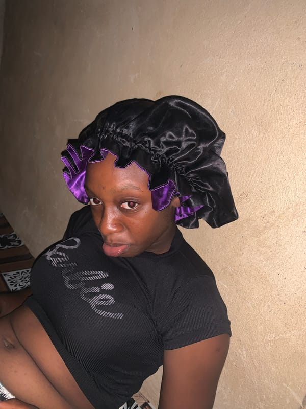 Woman in purple-trimmed bonnet captured smiling indoors